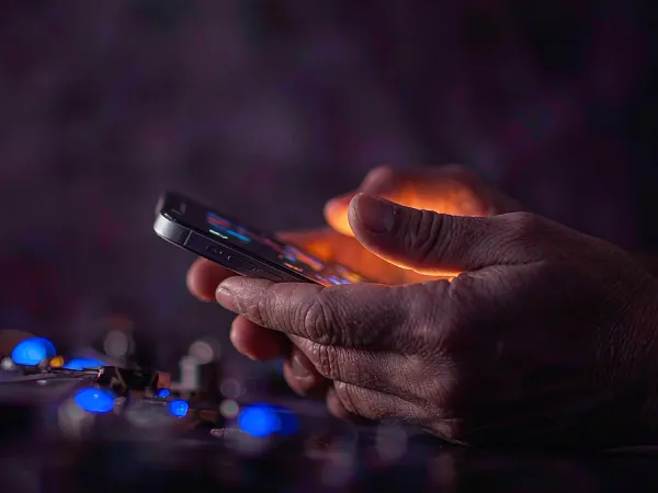 jjjpk Hands holding a smartphone in warm light
