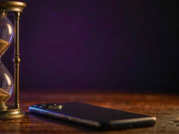 jjjpk Hourglass beside a smartphone on a wooden table